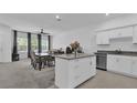 Open-concept kitchen and living room area with natural light and modern furnishings at 3039 Springwell Loop, Orlando, FL 32808