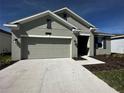 Charming single-story home featuring a two-car garage, well-manicured lawn, and neutral exterior paint at 34071 Sky Blossom Cir, Leesburg, FL 34788