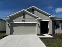 Charming single-story home featuring a two-car garage, well-manicured lawn, and neutral exterior paint at 34071 Sky Blossom Cir, Leesburg, FL 34788