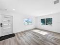 Inviting living room with gray hardwood floors, white walls, modern door, and large windows at 407 Sheryl Dr, Deltona, FL 32738