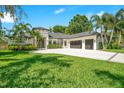 Beautiful modern home featuring manicured lawn, palm trees, and a spacious three-car garage at 4210 Waterfront Pkwy, Orlando, FL 32806