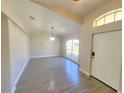 Bright foyer featuring neutral walls, ceramic wood-look flooring, a decorative light fixture, and a large window at 506 Peace Way, Kissimmee, FL 34759