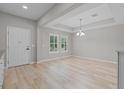 Bright, empty living room with hardwood floors and stylish recessed ceiling at 528 Seven Oaks Blvd, Winter Springs, FL 32708