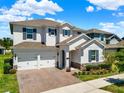 Two-story home with a two-car garage, brick driveway, manicured lawn, and stone veneer accents at 765 Terrapin Dr, Debary, FL 32713