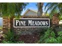 Attractive brick community sign reading 'Pine Meadows' surrounded by lush greenery at 825 Mellowood Ave, Orlando, FL 32825