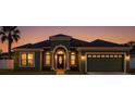 Inviting home exterior showcasing arched entryway, well-kept lawn, and a two-car garage under a twilight sky at 8325 Sun Vista Way, Orlando, FL 32822