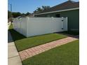 Newly installed white vinyl fence, creating a private backyard area with green lawn at 8325 Sun Vista Way, Orlando, FL 32822
