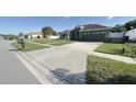 Landscaped front yard with a well-maintained lawn, decorative trees, and a concrete driveway leading to the garage at 8325 Sun Vista Way, Orlando, FL 32822