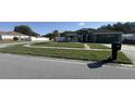 Well-kept front yard with lush grass, a brick walkway, and manicured shrubbery at 8325 Sun Vista Way, Orlando, FL 32822