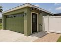 Attached two-car garage with an adjacent entryway and awning, complemented by a white privacy fence at 8325 Sun Vista Way, Orlando, FL 32822