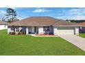 Charming single-story home with a well-manicured lawn and an attached two-car garage at 8509 Sw 136Th Loop, Ocala, FL 34473