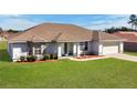 Well-maintained single-story home featuring a green lawn and an attached two-car garage at 8509 Sw 136Th Loop, Ocala, FL 34473