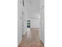Bright hallway with neutral tile floors leading to open living spaces and a sliding door at 10030 Cheshunt Dr, Orlando, FL 32817