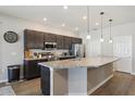 Spacious kitchen features dark wood cabinets and a large island with a granite countertop at 1052 Cascade Dr, Davenport, FL 33837