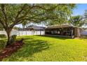 Large, well-maintained backyard featuring a lush lawn, mature trees, and a screened lanai at 1174 Snug Harbor Dr, Casselberry, FL 32707