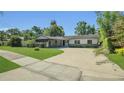 Beautiful single-story home featuring a curved driveway, lush lawn, and attractive landscaping at 1326 W Concord St, Orlando, FL 32805