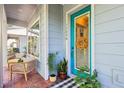 Charming front porch with brick flooring, seating, and a bright blue front door at 13890 Sato Ave, Orlando, FL 32827