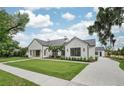Modern home exterior with white brick, black metal roof, palm trees, and landscaped front yard at 1400 Nottingham St, Orlando, FL 32803