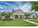 Beautiful exterior elevation of a white home featuring black trim, palm trees and green lawn at 1400 Nottingham St, Orlando, FL 32803
