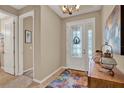 Bright foyer featuring decorative front door, chandelier, tile floor, and neutral paint at 1424 Palisades Lane, Deland, FL 32724