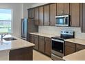Gourmet kitchen with stainless steel appliances, quartz countertops, and dark wood cabinetry at 14647 Crestavista Dr, Clermont, FL 34714