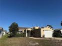 Inviting one-story home featuring manicured landscaping, charming details, and an attached garage at 1705 Betrillo Ct, The Villages, FL 32162