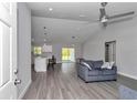 Open concept living room featuring vaulted ceilings, wood-look floors, and modern ceiling fan at 17468 Sw 36Th Ter, Ocala, FL 34473