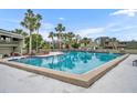 Large community pool with palm trees and seating area at 186 Scottsdale Sq # 186, Winter Park, FL 32792