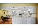 Bright kitchen featuring white cabinets, quartz countertops, a breakfast bar, stainless steel appliances, and hardwood floors at 222 Paul Mcclure Ct, Casselberry, FL 32707