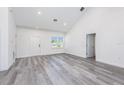 Bright living room with soaring ceilings, wood-look floors and natural light from a large window at 2808 Sw 139Th St, Ocala, FL 34473