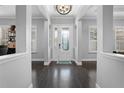 Elegant foyer with dark wood floors, chandelier lighting, decorative leaded glass door and bright interior at 306 Balfour Dr, Winter Springs, FL 32708