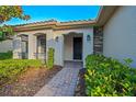 Inviting front porch with brick pavers, decorative columns, and lush landscaping at 307 Monterey St, Kissimmee, FL 34759