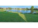 Picturesque view of a serene lake surrounded by lush green grass and neighborhood homes at 307 Monterey St, Kissimmee, FL 34759