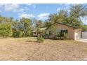 Spacious yard with a single-story home, complimented with lush landscaping and a metal roof at 360 Westchester Dr, Deland, FL 32724