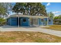 Bright blue single-story home featuring a covered carport and concrete driveway at 451 Hibiscus Rd, Casselberry, FL 32707