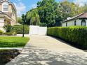 Long driveway leading to a gated home, surrounded by lush greenery and mature trees at 702 Palenci Ct, Winter Springs, FL 32708