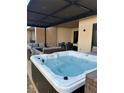 Inviting hot tub with lounge seating and dining area under a covered patio at 7567 Brooklyn Dr, Kissimmee, FL 34747