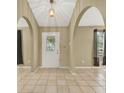 Inviting foyer with arched doorways, tile flooring, and a decorative front door at 9290 Lake Sharp Ct, Orlando, FL 32817
