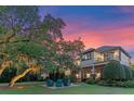 Beautiful home exterior at dusk with a manicured lawn, brick patio, and mature trees at 9624 Bryanston Dr, Orlando, FL 32827