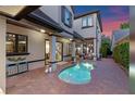 Outdoor pool on a brick patio featuring an entertaining area with columns and a sunset backdrop at 9624 Bryanston Dr, Orlando, FL 32827