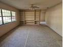 Bright living room with large windows and built-in shelving, offering ample natural light and storage at 9741 Se Highway 464C Se Hwy, Ocklawaha, FL 32179