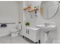 Clean half bathroom featuring a modern sink, round mirror, and neutral colors at 11148 Amber Ridge Dr, Zellwood, FL 32798
