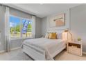 Comfortable bedroom with a large window, natural light, modern furniture, and neutral color palette at 11148 Amber Ridge Dr, Zellwood, FL 32798