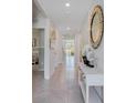 Bright hallway showcasing modern decor, neutral colors, tile flooring, and access to multiple rooms at 11148 Amber Ridge Dr, Zellwood, FL 32798