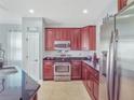 Well-equipped kitchen with cherry cabinets, stainless steel appliances, and granite countertops at 14242 Avenue Of The Groves, Winter Garden, FL 34787