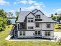 Stately two-story home boasts an outdoor balcony, lush lawn, and tranquil lake views at 16692 Lake Pickett Rd, Orlando, FL 32820