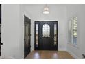 Bright foyer with light hardwood floors, a decorative front door, and white trim at 16692 Lake Pickett Rd, Orlando, FL 32820