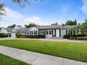 Traditional home boasts a well-kept lawn, manicured shrubs, and mature trees, offering great curb appeal at 1702 N Westmoreland Dr, Orlando, FL 32804