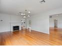 Bright living room boasts hardwood floors, white trim, fireplace, and views into the kitchen and entry at 1702 N Westmoreland Dr, Orlando, FL 32804