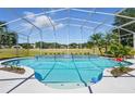 Inviting screened-in pool area with clear blue water, and beautiful landscaping at 1851 Sweetwater West Cir, Apopka, FL 32712